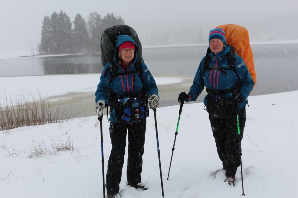 Anita Henriksen (t.v.) og Gretha Skaug tar farvel med gapahuken i Brustadvika i snødrev torsdag 26. mars i sin videre marsj nordover til toppen av Norge.