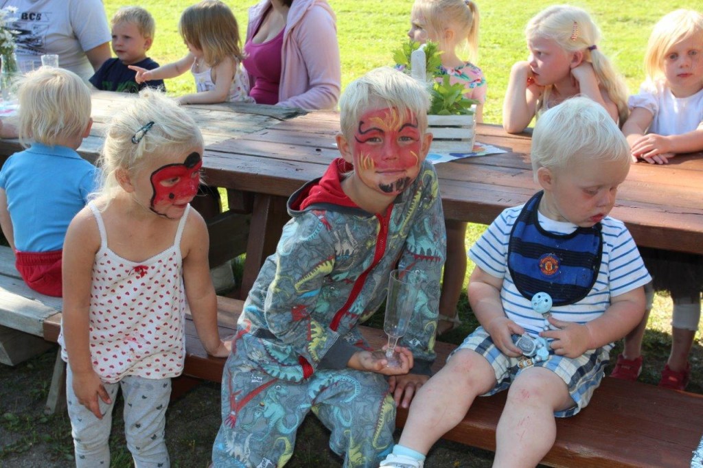 Glade barn med maling i ansiktet.